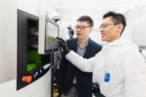 Professor Yu Zou and a graduate student with a metal 3D printer (Photo: Neil Ta)