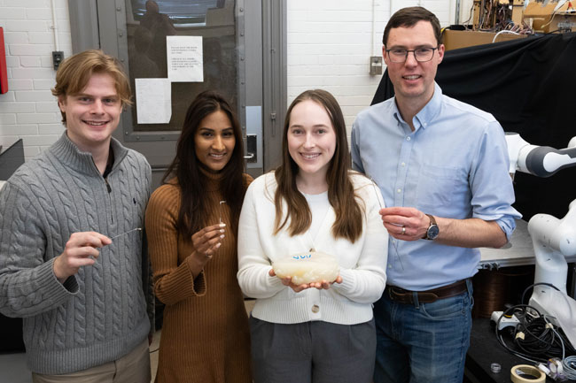 U of T Engineering researchers Erik Fredin, Anastasia Aubeeluck, Haley Mayer (all MIE PhD Students) and Professor Eric Diller (MIE) are some of the members of the team that designed a new set of tiny robotic tools for minimally invasive brain surgery. (photo by Tyler Irving)